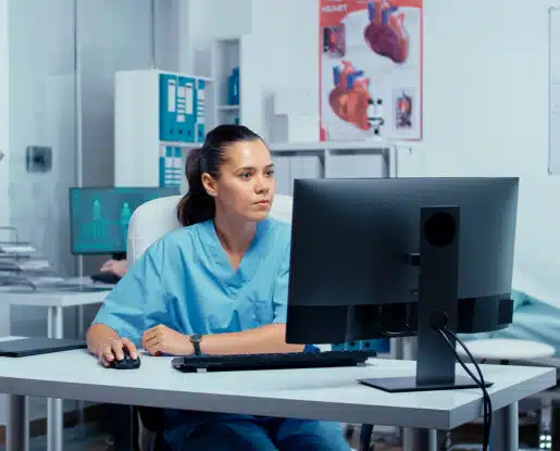 Infirmière libérale préparant sa déclaration des revenus sur ordinateur dans son cabinet