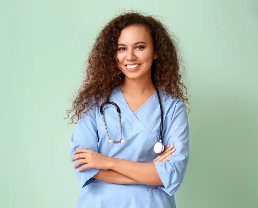 Jeune femme souriante en blouse médicale illustrant le parcours pour devenir infirmière libérale