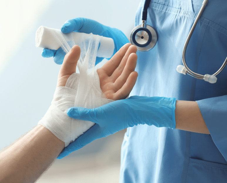 Infirmière posant un pansement sur la main d’un patient avec des gants bleus