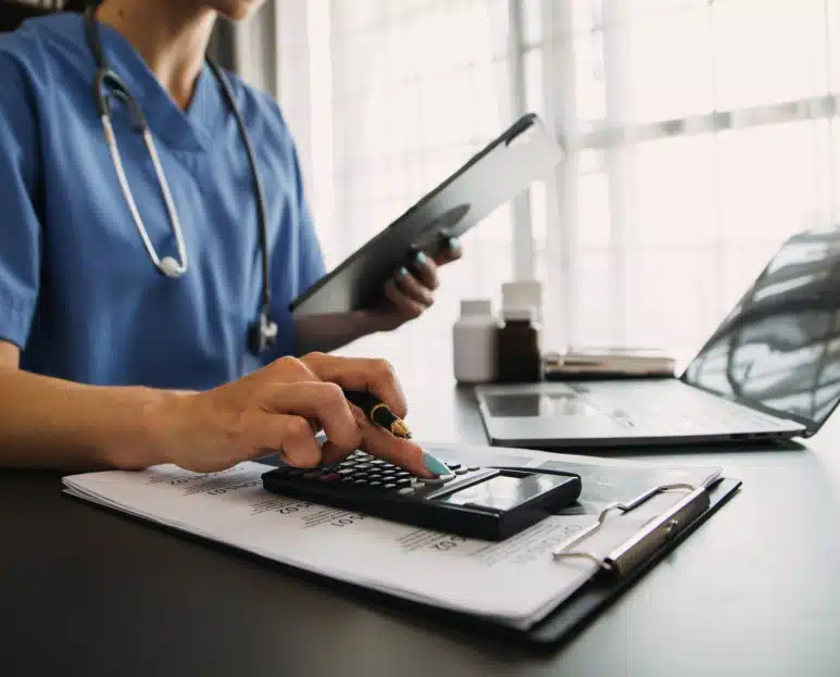 Facturation électronique infirmière libérale : gestion administrative Infirmière libérale utilisant une tablette et une calculatrice pour gérer sa facturation électronique
